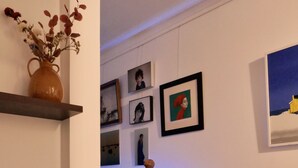 Un salon moderne avec une console en bois foncé, un vase de fleurs et un fauteuil à motifs écossais.