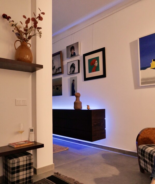 A modern living room with a dark wooden console table, a vase with flowers, and a plaid-patterned armchair.