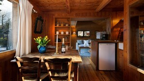 A wooden cabin interior with a dining area, a living room, and a kitchen. - Mazot Les Tines, with hot tub (Chamonix-Mont-Blanc)