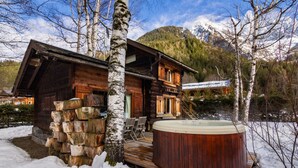 A wooden cabin with a hot tub, surrounded by snow and birch trees, with mountains in the background. - Mazot Les Tines, with hot tub (Chamonix-Mont-Blanc)