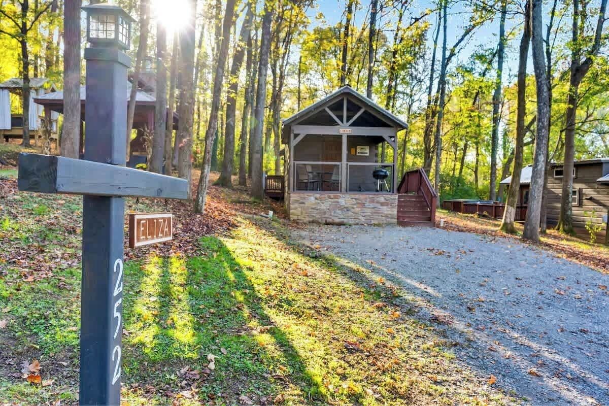 Eine Holzhütte mit Steinunterbau, umgeben von Bäumen.