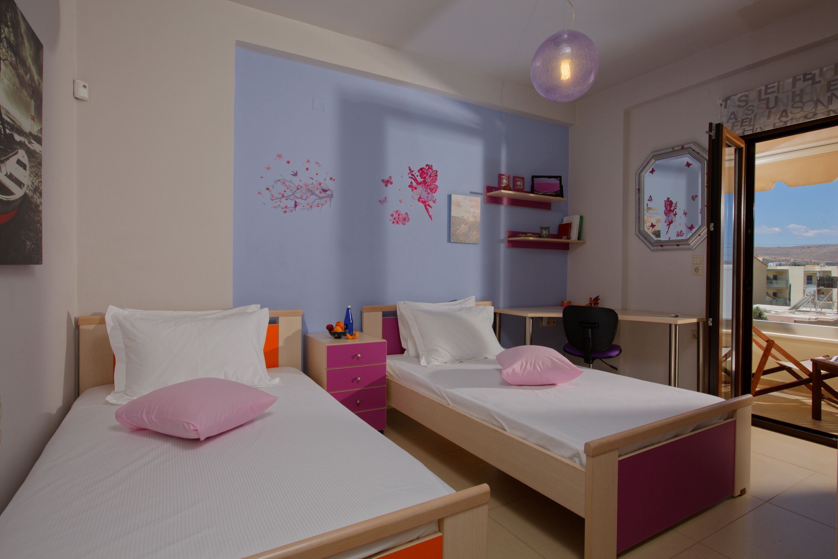Une chambre d’hôtel avec deux lits, un bureau et une fenêtre donnant sur un paysage agréable.