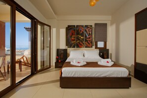 A spacious bedroom with a large bed, a sliding glass door leading to a balcony, and a city view. - Beatiful Villa in Gouves, Sea Views, Crete (Hersonissos)