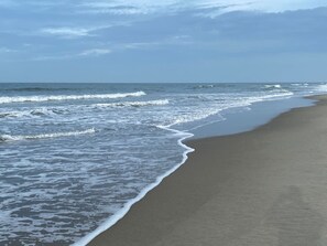 A beach with waves lapping onto the shore. - Beachski's Bungalow adorable 2 Bedroom, 2 Bath with Pool! Private Beach Access! (Holden Beach)