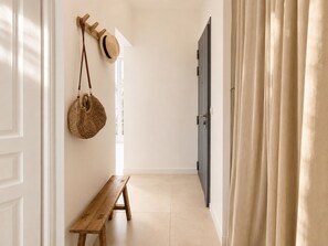 A hallway with a wooden bench, a hat rack, and a door. - The hacienda - Patio Terrace - Center / Beach 5 min (Le Havre)