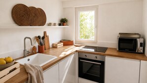 Eine moderne Küche mit Spüle, Herd, Mikrowelle und einem Fenster für natürliches Licht.