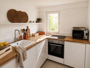 A modern kitchen with a sink, stove, microwave, and a window providing natural light. - The hacienda - Patio Terrace - Center / Beach 5 min (Le Havre)