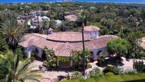 A large villa with a tiled roof, surrounded by lush greenery and a view of the ocean. - Palatial Villa in Hacienda Las Chapas, Marbella (Marbella)