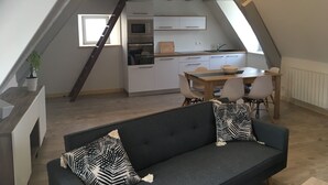 A cozy attic bedroom with a sloped ceiling, a built-in desk, and a dining area. - Waterfront duplex in the heart of the historic center (Roscoff)