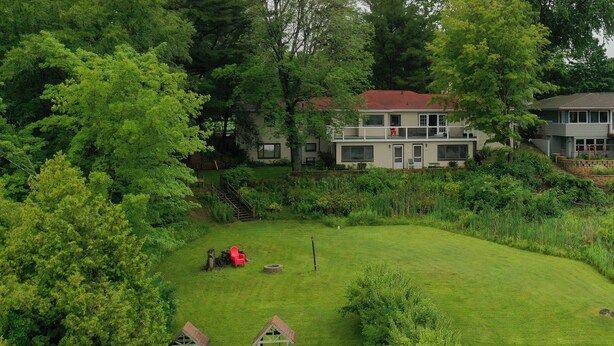 Un quartier résidentiel comprenant une grande maison, un petit chalet de jeu et une pelouse bien entretenue.