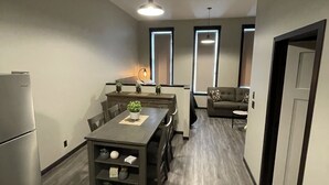 A modern kitchen with a dining area, a ceiling fan, and a refrigerator. - NEW, NEW, NEW!  Wabasha downtown studio113 Pembroke Ave Unit #102 (Wabasha)