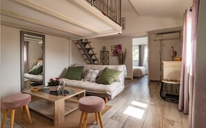 A modern living room with a sofa, coffee table, and a staircase leading to an upper level.