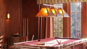 A pool table in a room with wooden walls and a hanging lamp. - 2 bedroom Condo at Hyatt Lake Tahoe - May 29th - June 4th (Incline Village)