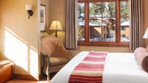 A hotel room with a large bed, a chair, a lamp, and a window with curtains. - 2 bedroom Condo at Hyatt Lake Tahoe - May 29th - June 4th (Incline Village)