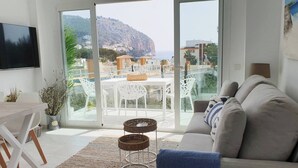 Un soggiorno moderno con un divano, una televisione e un'area pranzo con sedie e tavolo.