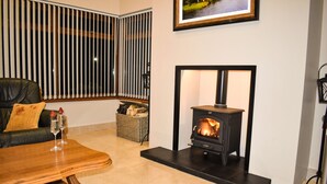 A cozy living room with a fireplace, a sofa, a coffee table, and a framed picture on the wall. - Glenshane Country House (Maghera)