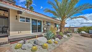 A modern house with a patio area featuring cacti, rocks, and a palm tree. - Desert Oasis with Pool, Fire Pit, Game Room, and Dry Bar (Borrego Springs)