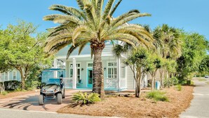 A house with a porch, a palm tree, and a golf cart parked in front. - Family Beach Escape! Pool Access + Kayaks, Bikes & Paddleboard Included (Santa Rosa Beach)