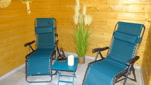 Two blue chairs with metal frames, a small table, and a decorative plant in a wooden room. - Le Chalet au Vieux Vignoble, a spacious cottage in Alsace near Saverne, offers c (BOUXWILLER)