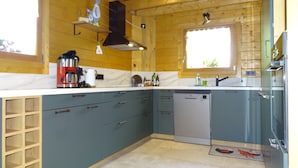 A kitchen with wooden walls, a window, a coffee maker, and a dishwasher. - Le Chalet au Vieux Vignoble, a spacious cottage in Alsace near Saverne, offers c (BOUXWILLER)