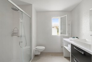 Chuveiro, secador de cabelo, toalhas de banho, papel higiênico