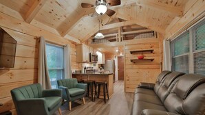 A wooden cabin interior with a kitchen, dining area, and seating. - Martha Tiny Cabin at Lookout Close to Downtown (Chattanooga)