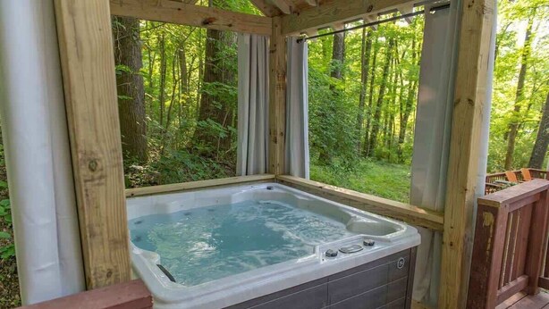 A hot tub in a wooden deck with a view of a forest. - Martha Tiny Cabin at Lookout Close to Downtown (Chattanooga)