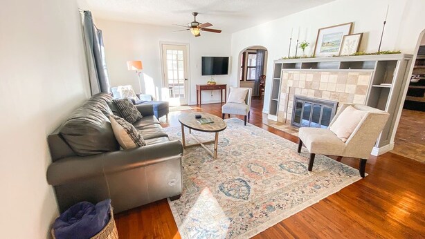A living room with a sofa, armchair, coffee table, and fireplace. - Cardinal House: Foseball, Sunroom, 6ft Fence, King Bed, Near Hospital & BassPro (Springfield)
