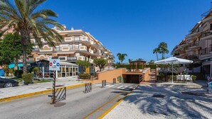 Een hotel met meerdere verdiepingen, balkons, een Buddha House restaurant en palmbomen.
