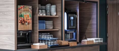 A kitchen with wooden cabinets, a coffee machine, and a microwave.