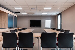 A conference room with a long table, black chairs, a flat-screen TV, and a whiteboard. - Holiday Inn Express Ajaccio by IHG (Ajaccio)