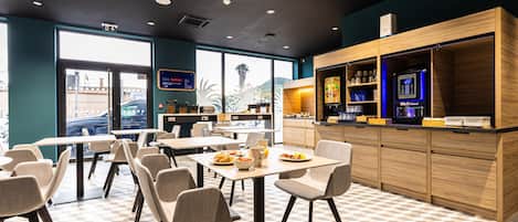 A modern cafe with tables and chairs, a coffee machine, and a counter with a menu.