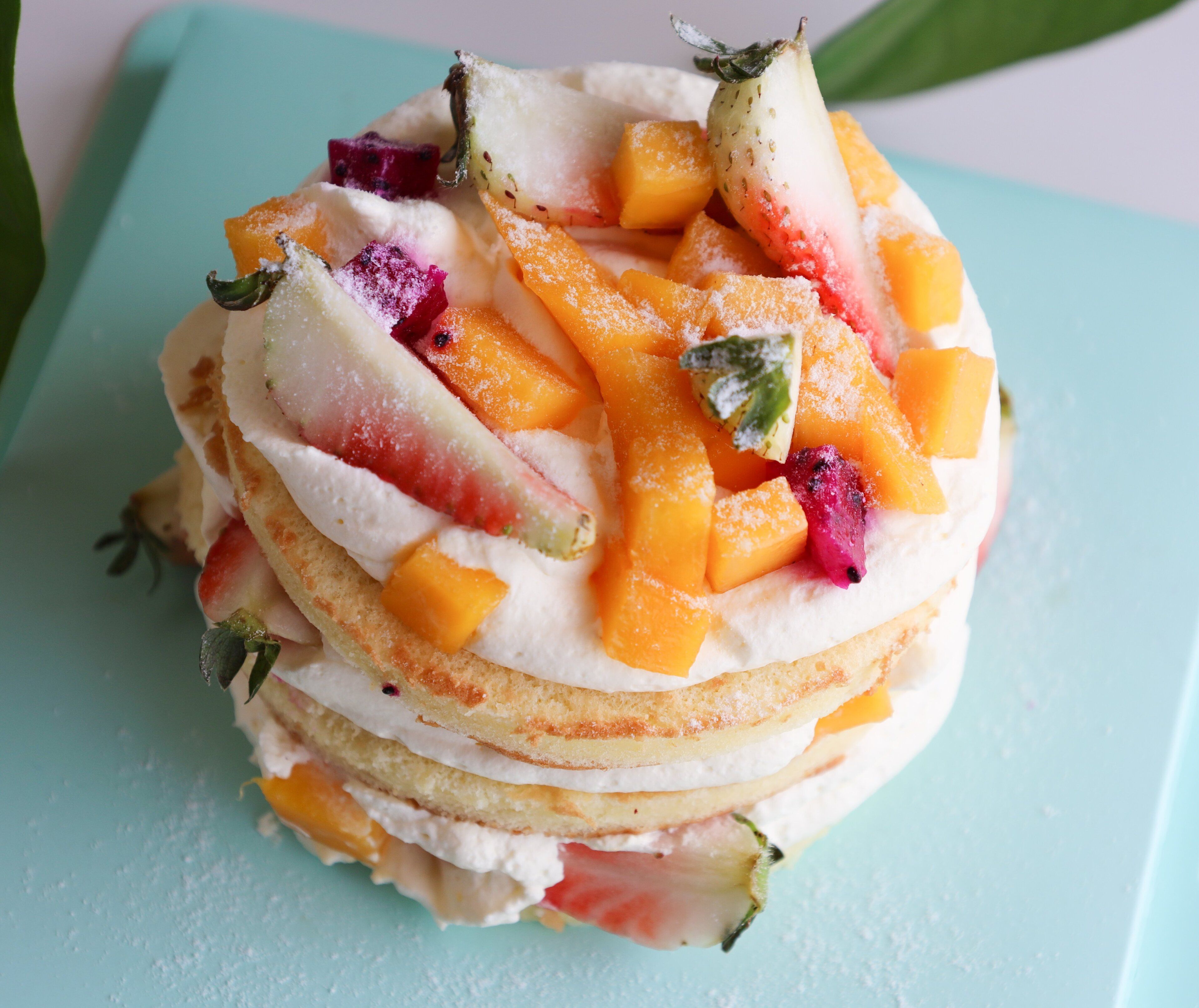 A stack of pancakes with fruit toppings.