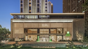 A modern hotel with a prominent entrance, large windows, and a visible sign for Holiday Inn Express.