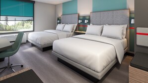 Moderni hotellihuone, jossa on kaksi sänkyä, työpöytä ja tuoli.