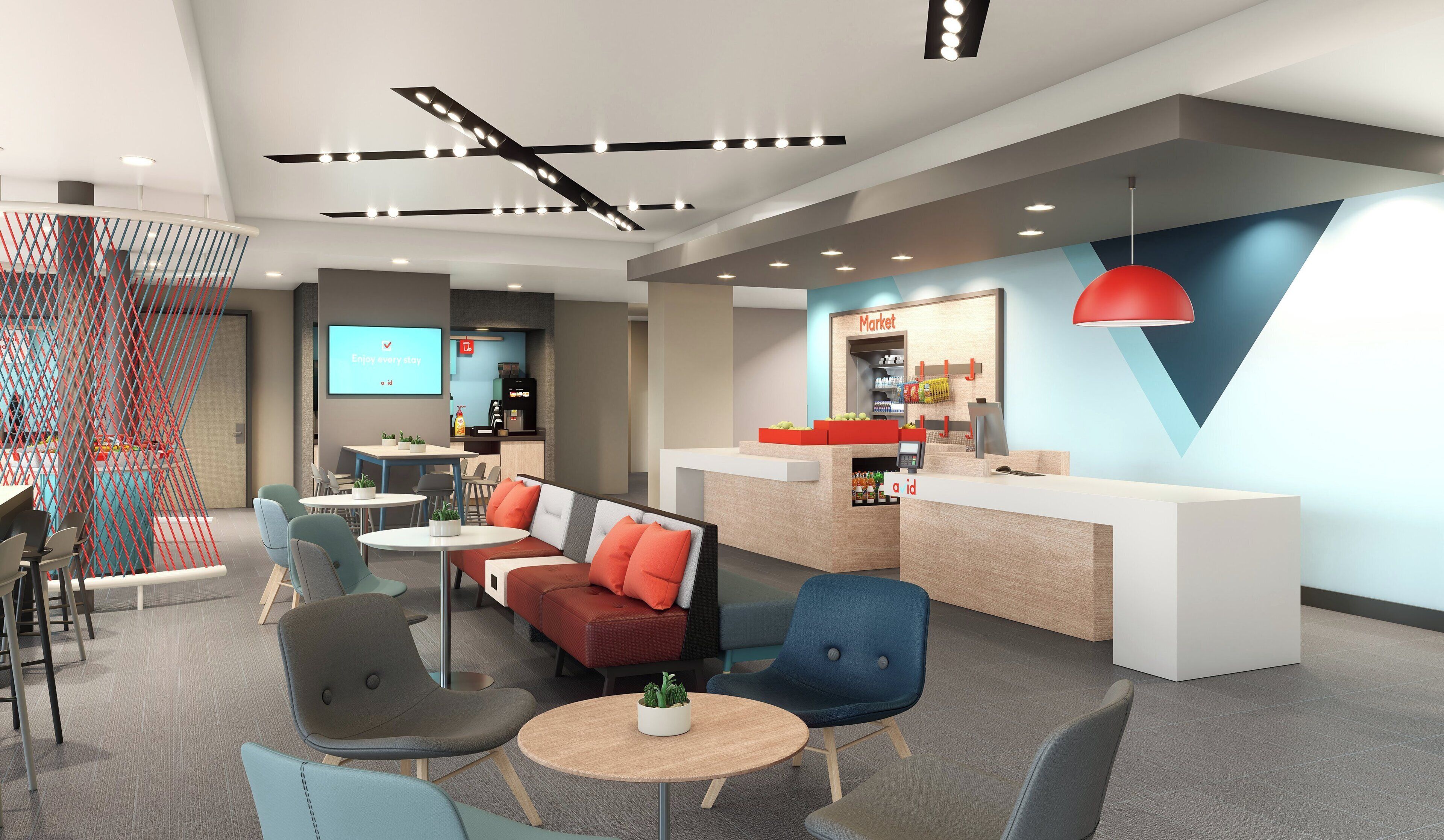 A modern hotel lobby with seating areas, a reception desk, and a coffee machine.
