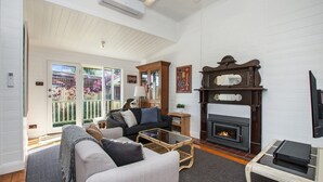 Una sala de estar con chimenea, un sofá, una mesa de centro y una televisión.