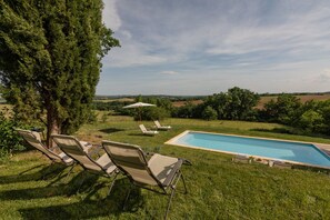A pool area with lounge chairs and a view of the countryside. - Stone Cabin with Swimming Pool - King-Size Beds & Views of the Pyrenees (Gondrin)