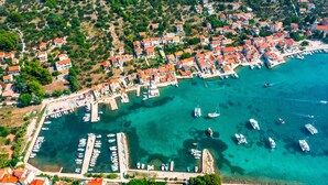 An aerial view of a coastal town with a marina, houses, and boats. - Private stone villa on the island for 10 people with pool and sea view (Prvic Luka)