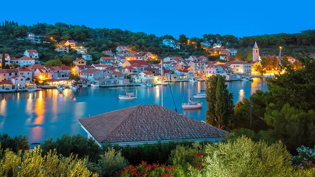 A coastal town at dusk with buildings along the waterfront, a church, and boats in the marina. - Private stone villa on the island for 10 people with pool and sea view (Prvic Luka)