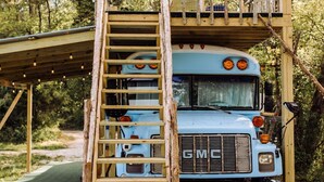 Een blauwe GMC-vrachtwagen met een houten ladder die naar een platform leidt.