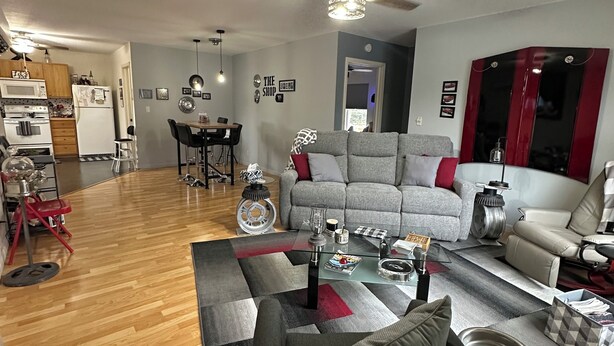 A modern living room with a grey sofa, a glass coffee table, and a dining area with a table and chairs. - "THE SHOP" retro 60's (Keosauqua)