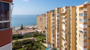 Een hoog gebouw met meerdere balkons met uitzicht op een strand.