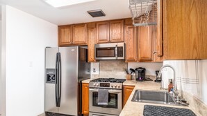 Une cuisine moderne avec des meubles en bois, des appareils en acier inoxydable et un plan de travail en granit.