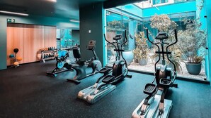 Ein modernes Fitnessstudio mit Laufbändern, Crosstrainern und Kurzhanteln.