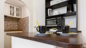 A kitchen with a microwave, coffee maker, and cabinets. - GuestHost - Modern and cozy 25 sqm studio apartment, ideal for two people, located on the 2nd floor of a characteristic period building without lift. The property is located within the Traffic-Restricted Area of the historic center and is the ideal solut (Firenze)