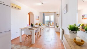 A modern apartment with a dining area, kitchen, and living space. - Apartamento Ladera by Solset (Málaga)