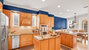 Une cuisine moderne avec des meubles en bois, des appareils électroménagers en acier inoxydable et un grand îlot central.