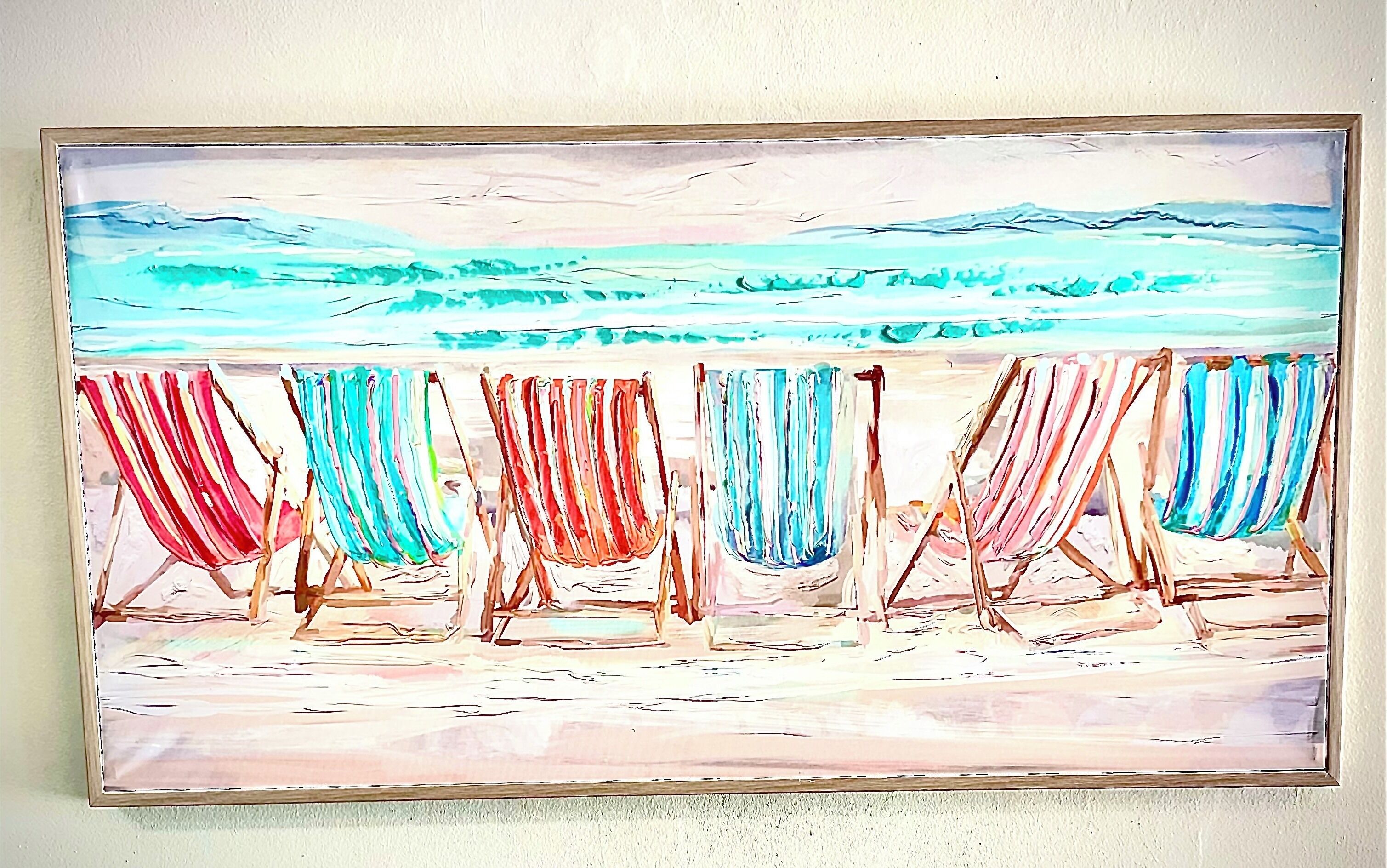 Escena de playa con hileras de sillas y vista al océano.