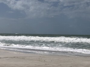 A beach with waves crashing onto the shore under a cloudy sky. - ONE BEDROOM CONDO ONE BLOCK TO BEACH (Bradenton Beach)
